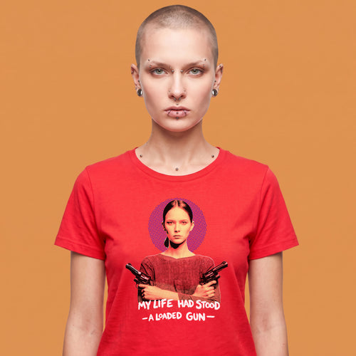 Camiseta de mujer de algodón orgánico rojo con ilustración gráfica de una mujer con dos armas y el texto My Life Had Stood A Loaded Gun en blanco, con detalle de QUADRA impreso en la manga izquierda